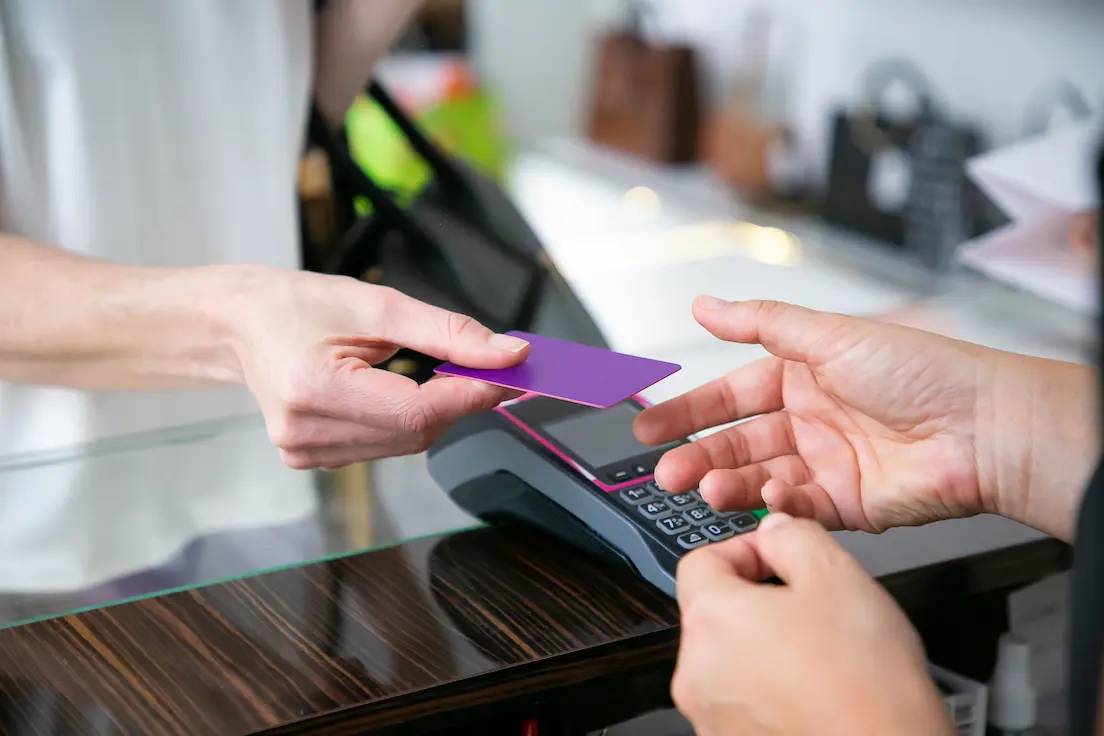 cliente dando cartão de crédito ao caixa no balcão para pagamento