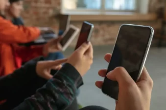 Jovens no celular vendo algo que foi compartilhado e se tornando viral, como na pornografia de vingança ou revenge porn